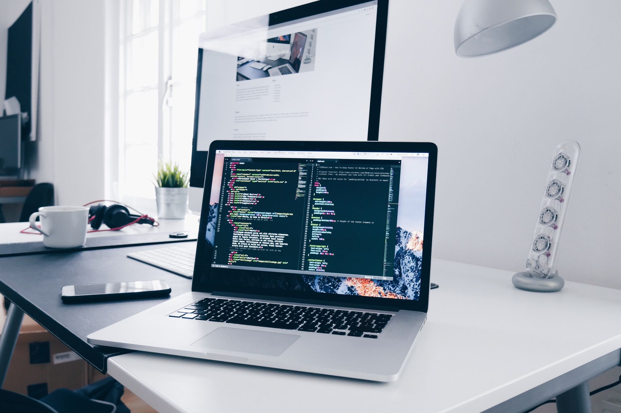 Laptop with code on white desk