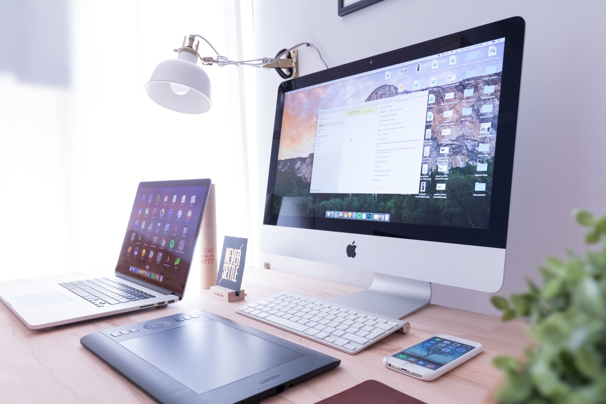 Computer, laptop and phone on desk